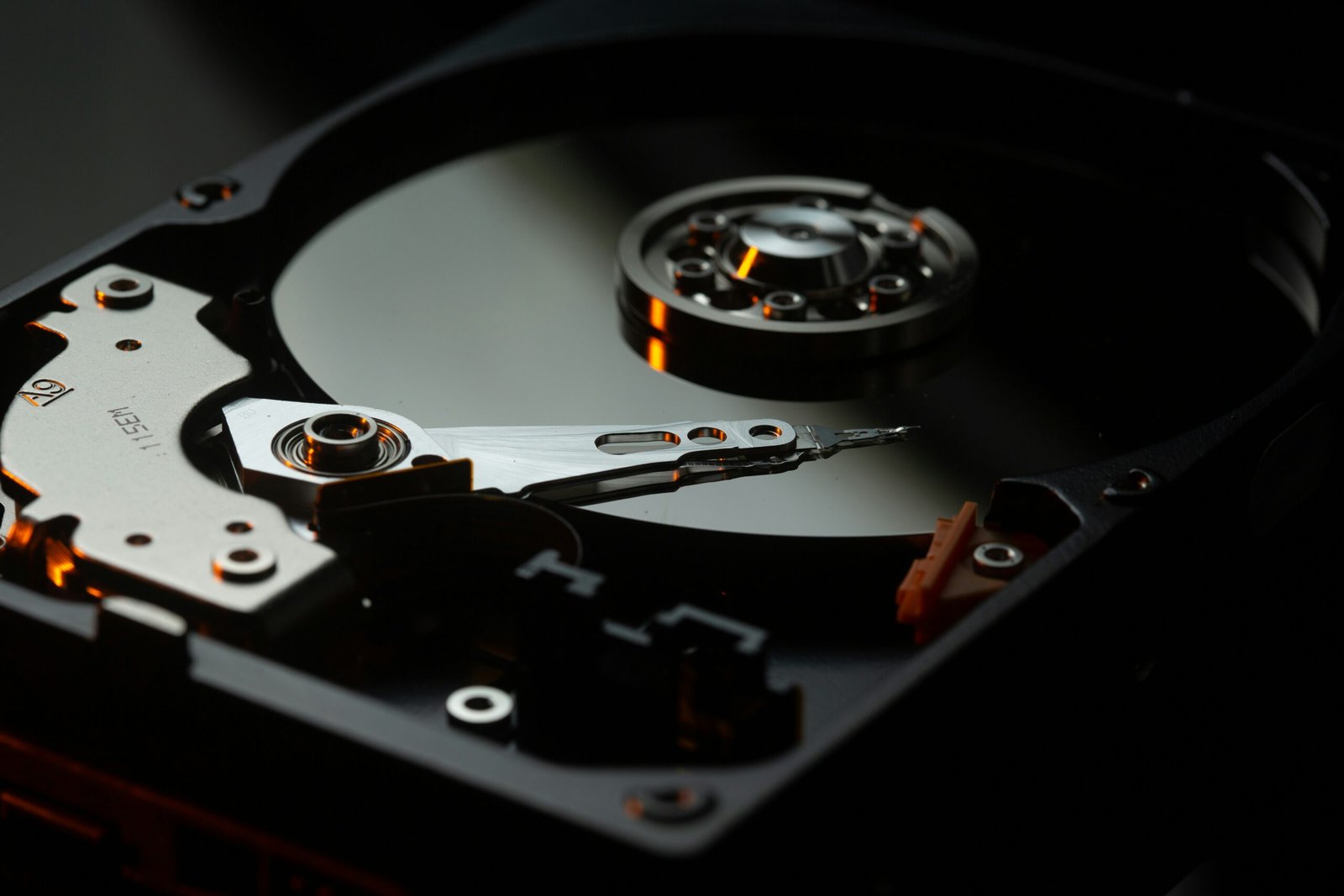Inside view of an open hard drive showing the platter and read write arm, the kind of mechanical wear that causes clicking and failure symptoms