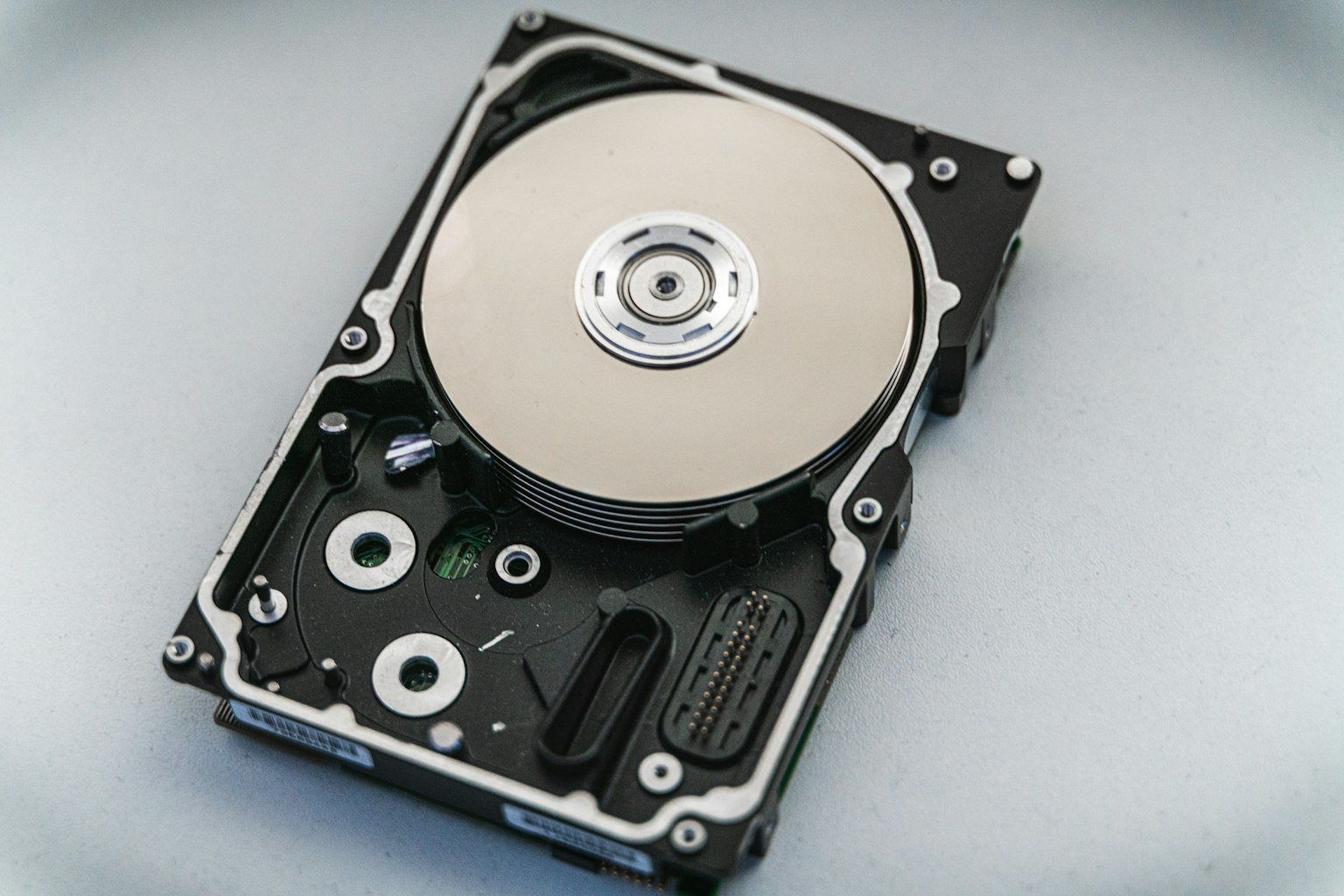 Hard disk drive with its cover removed, showing the spinning platter and read/write head assembly